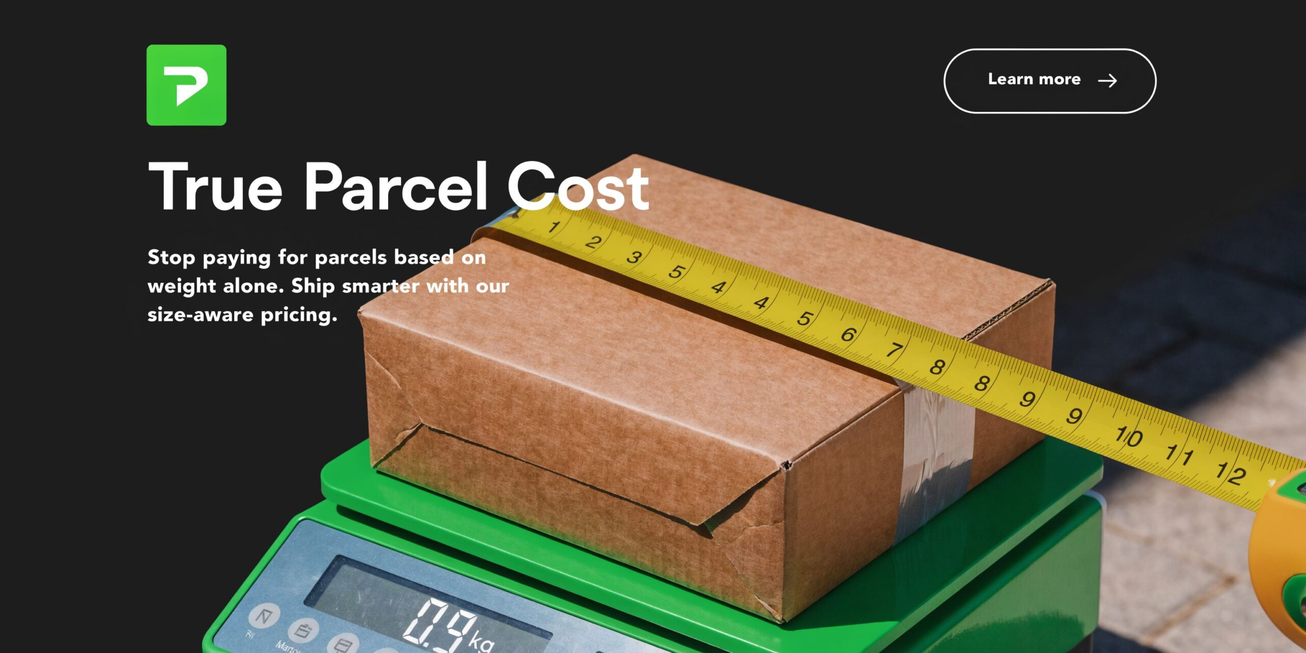 A cardboard box on a green digital scale with a yellow measuring tape across the top.
